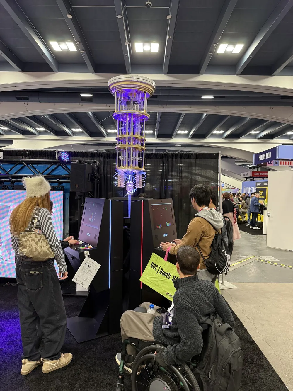 Attendees gathered around the Quantum Arcade booth at GDC 2026, the lit quantum-processor sculpture at its center